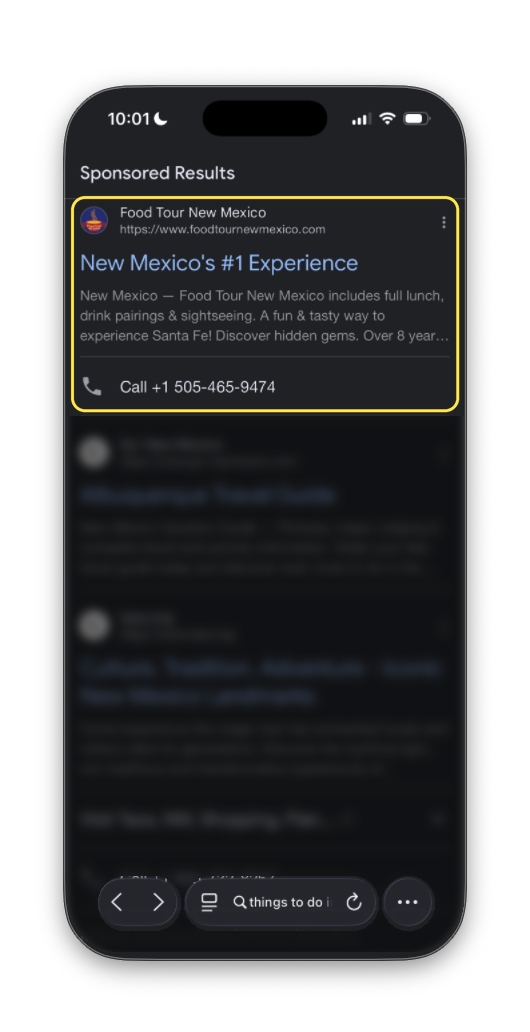 Google search results in dark mode with the Food Tour New Mexico ad outlined and the rest of the results blurred. The ad reads “New Mexico’s #1 Experience” and describes “a fun & tasty way to experience Santa Fe!”, with a call button.