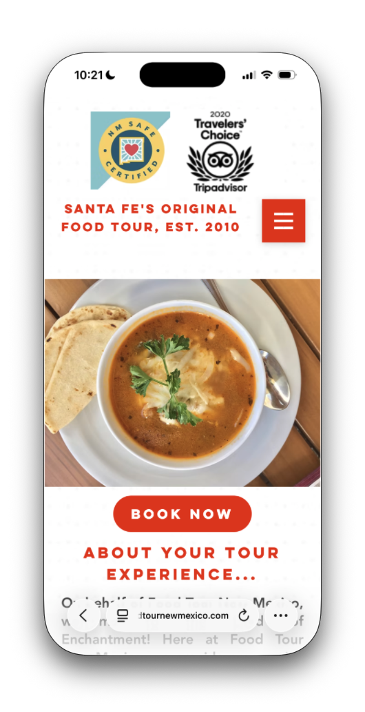 The Food Tour New Mexico site without the cookie notice: an NM Safe Certified badge and a 2020 Tripadvisor Travelers’ Choice badge, the tagline “Santa Fe’s Original Food Tour, est. 2010”, a menu button, a photo of soup, and a red Book Now button.